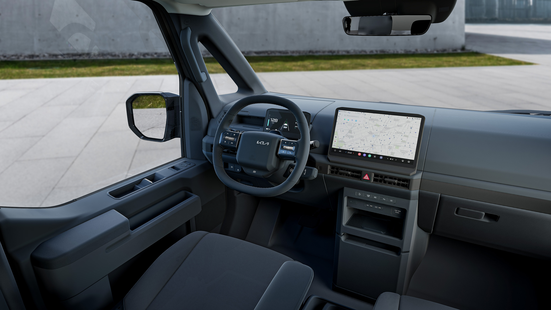 Kia PV5 Passenger cockpit with a digital cluster, heated steering wheel, climate-controlled seats, and navigation display.