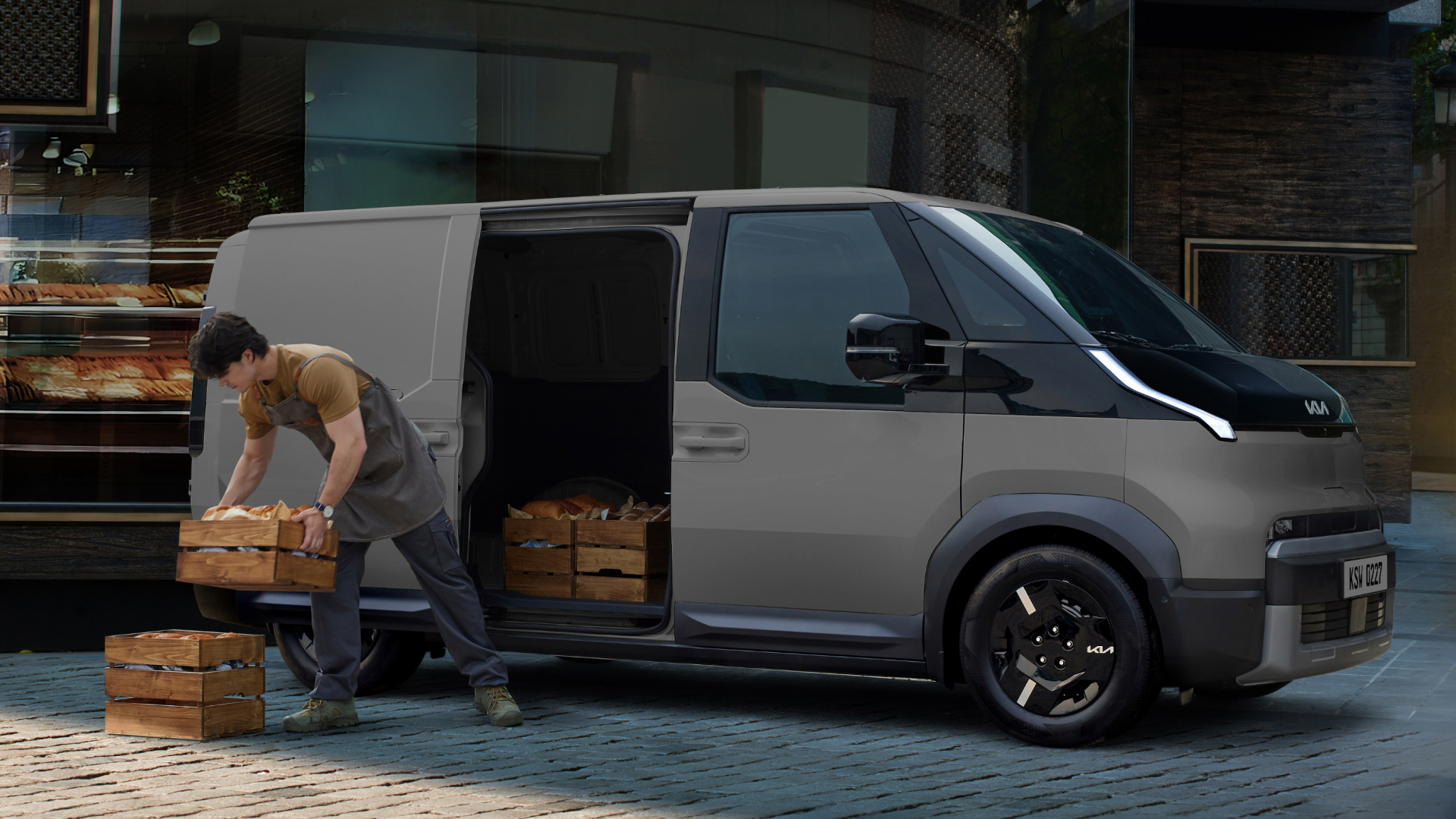 Worker unloading bread crates from the Kia PV5 Cargo side door