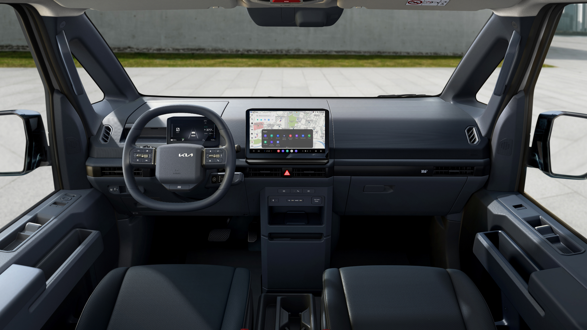 Front driver’s view of Kia PV5 interior showing steering wheel and infotainment display