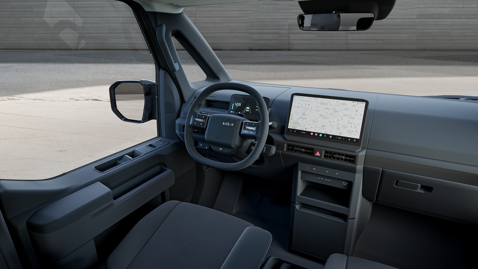 Angled interior view of the Kia PV5 cockpit showing the driver's seat, steering wheel and infotainment display