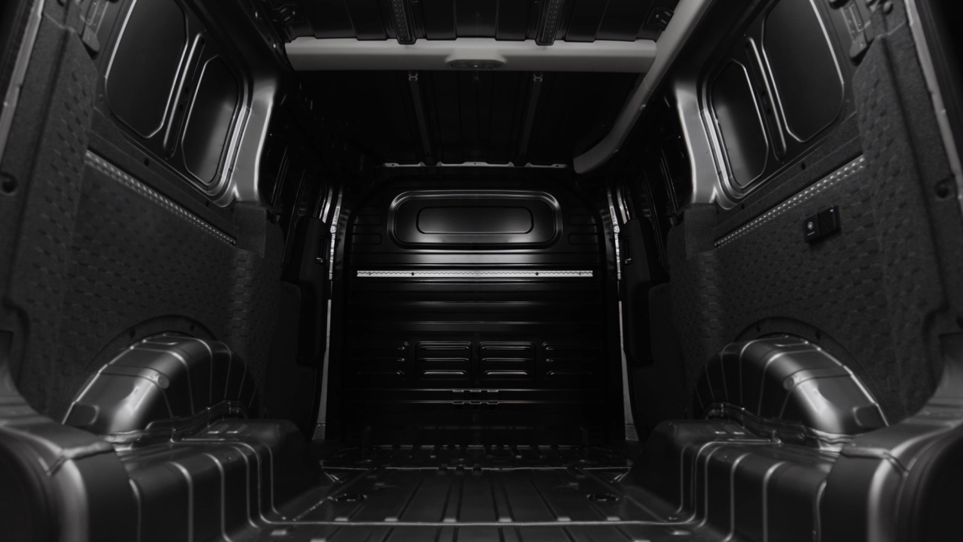 Interior view of the empty cargo bay of the Kia PV5 Cargo, seen from the rear