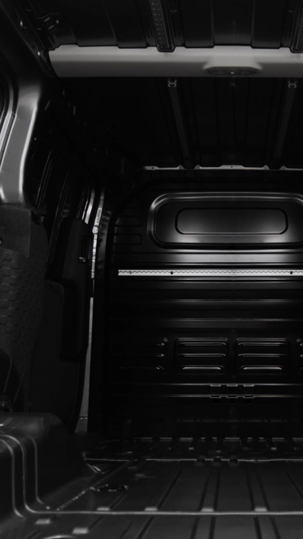 Interior view of the empty cargo bay of the Kia PV5 Cargo, seen from the rear